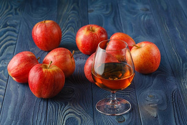 glass of Calvados Brandy and red apples
